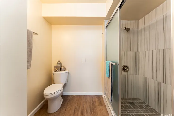 Updated shower stall with ceramic tile and glass enclosure.