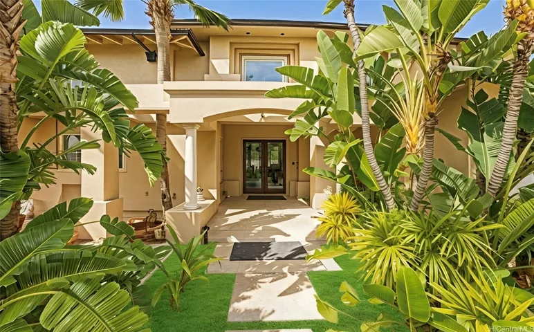 Front of home with mature palm landscaping. Enhanced.