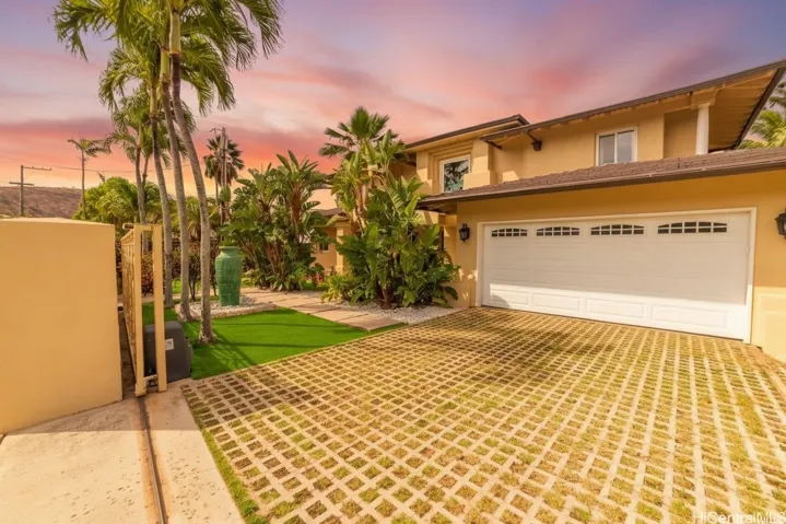 Front exterior with paver driveway and gated entry. Enhanced.