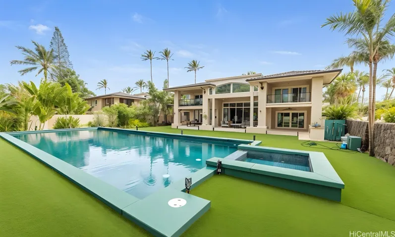 Daytime view of pool, spa, and rear elevation. Enhanced.