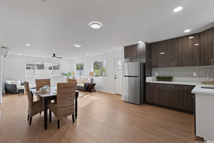 Downstairs dining and living room with the view of the wet bar and refrigerator