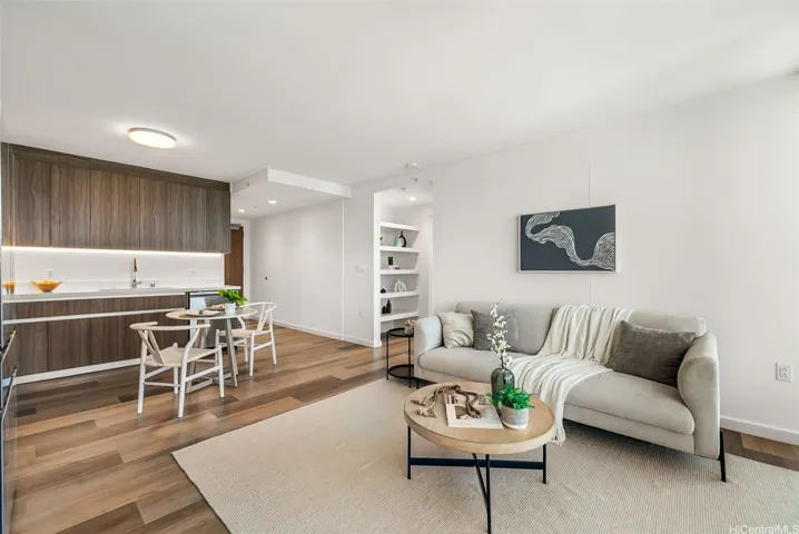Bright, open-concept living, dining, and kitchen area with contemporary finishes and warm wood flooring