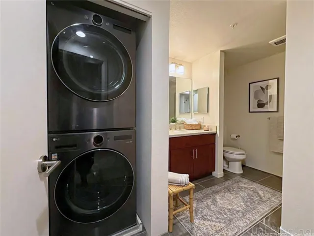 Enhanced & Virtually Staged - second bathroom with large, stacked washer and dryer