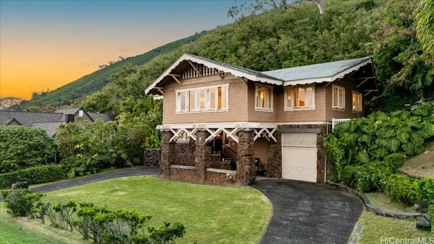 A timeless Manoa residence, beautifully framed by lush valley greenery and a gracious front lawn.