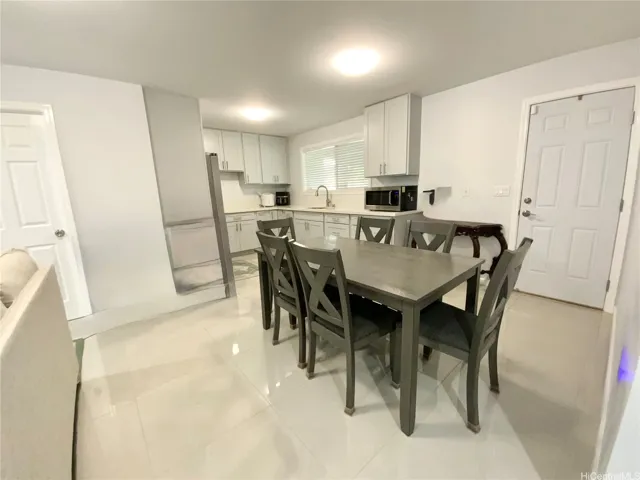 Wet bar-style kitchenette downstairs next to additional living room. Disclaimer: Enhanced. Photo has been edited to show the room with fewer items for clarity.