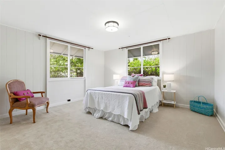 The primary suite features original oversized sliding windows, new carpet and ceiling light.