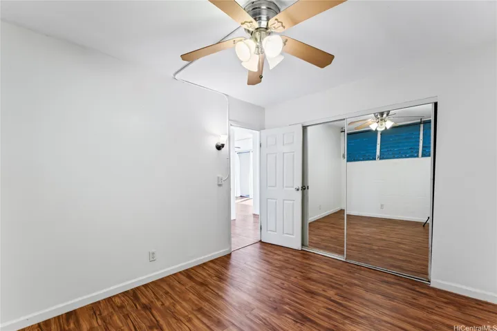 Another angle of the second bedroom featuring mirrored closet doors.