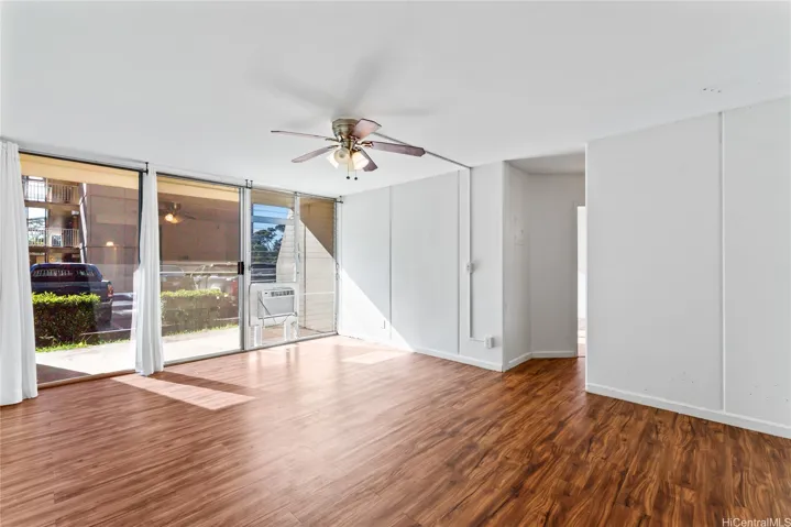 A sunlit living room with large sliding glass doors, and direct access to an outdoor area.