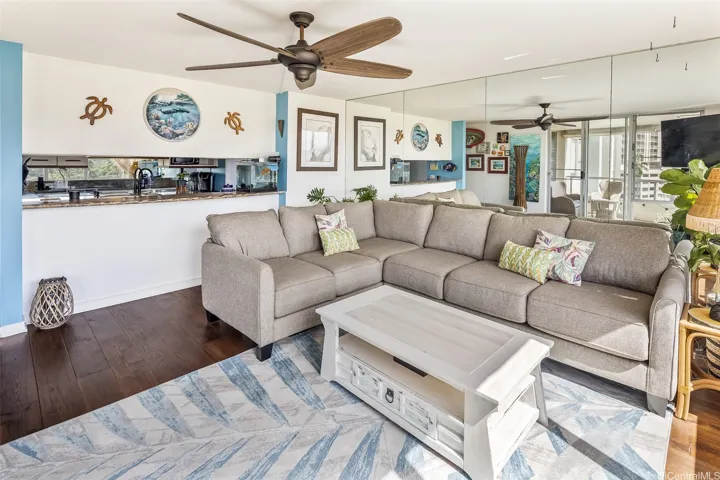 View from the lanai walking into the bright, open living room, highlighting the roomy sectional seating and smooth indoor-outdoor flow for relaxing or entertaining.