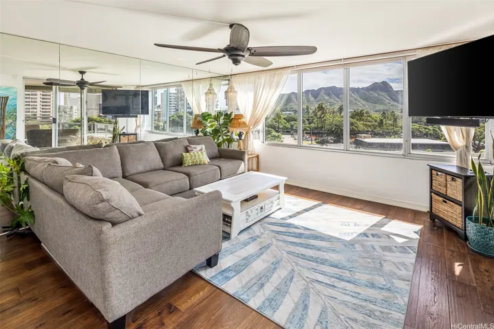 Bright, inviting living room with walls of windows framing Diamond Head as the centerpiece view, filling the space with soft natural light and a relaxing island vibe.