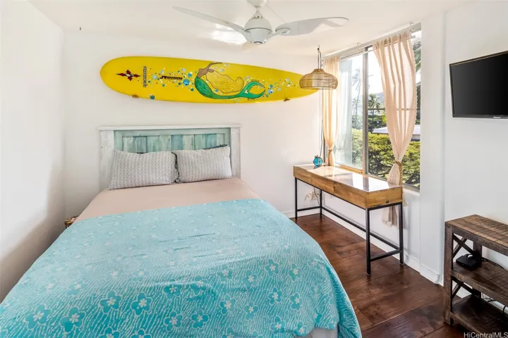 Bright second bedroom with hardwood floors, plenty of natural light, and cooling tradewind breezes.