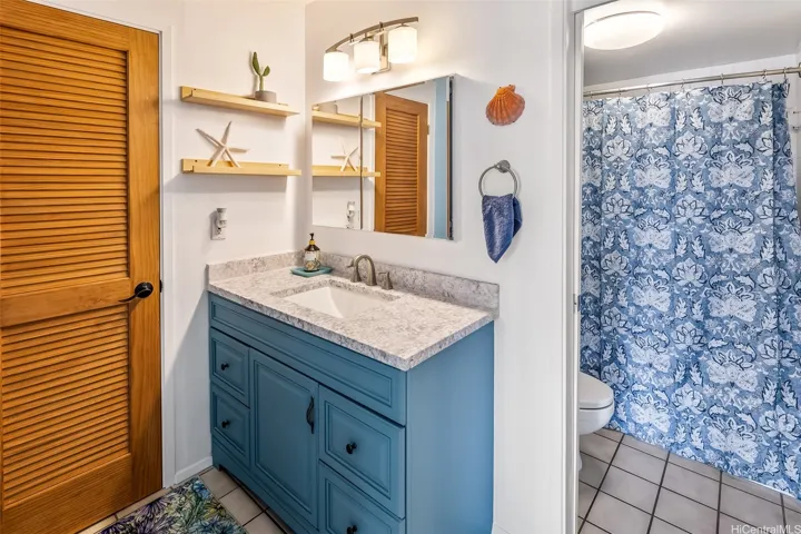 Cheerful primary en suite bath with a roomy vanity, closet storage, and a tub/shower combo for relaxing soaks or quick rinses