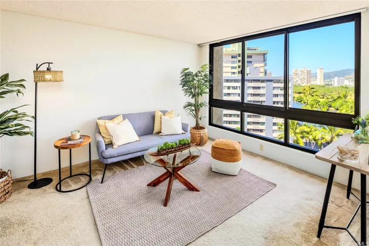 Living room has large window with Ala Wai canal/mountain view