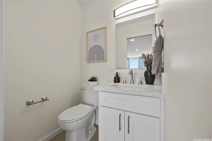 Half bath near kitchen remodeled with new vanity, toilet, fixtures and luxury vinyl flooring