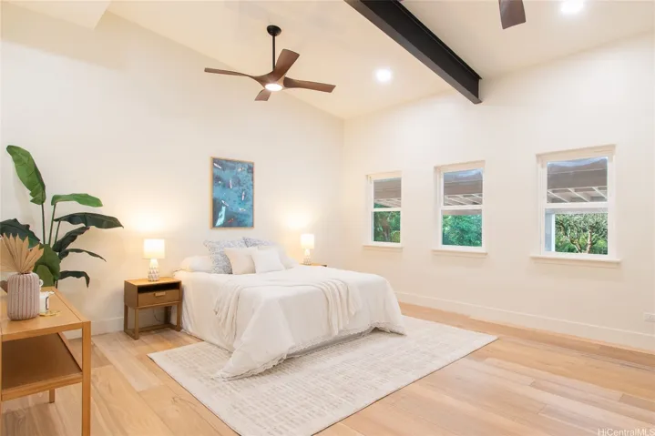 Large secondary bedroom, art studio, or work space comes equipped with 5 windows, 2 ceiling fans, and high vaulted ceilings.