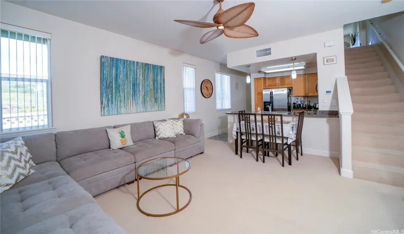 Open living area with kitchen and staircase leading upstairs