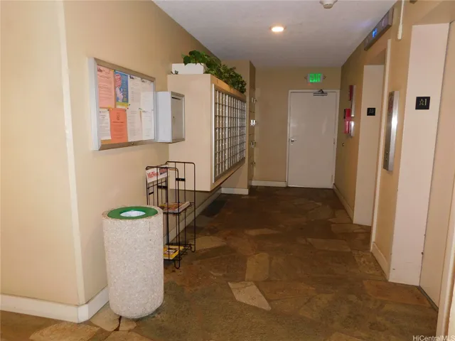 Lobby with mailboxes and two elevators.