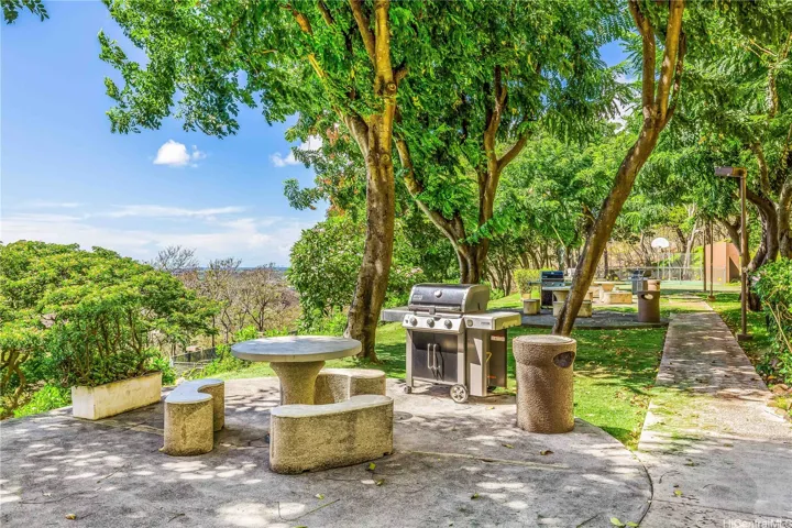 seating area near basketball, putting green and corn hoe complete with BBQ grills