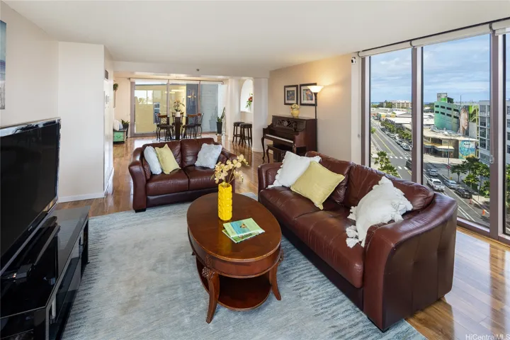 The living room also seamlessly connects to the dining space and entrance. Enhanced photo.