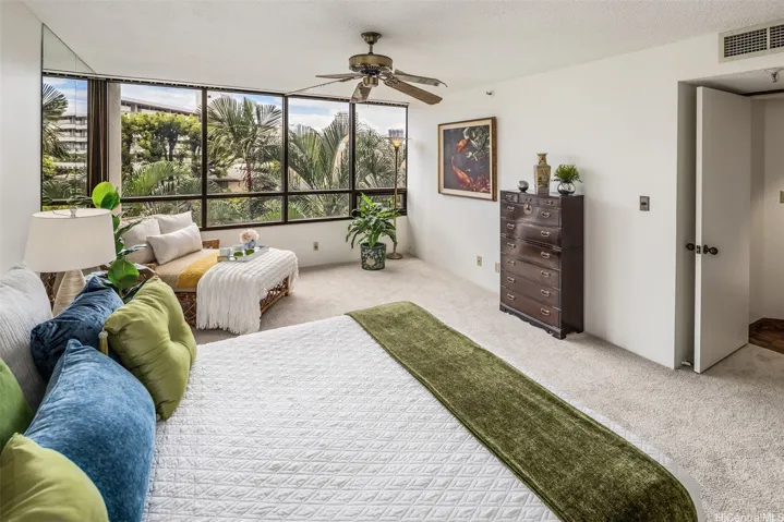 Soothing palm tree views form the entire Primary Suite. What lovely greenery to see from your bed!