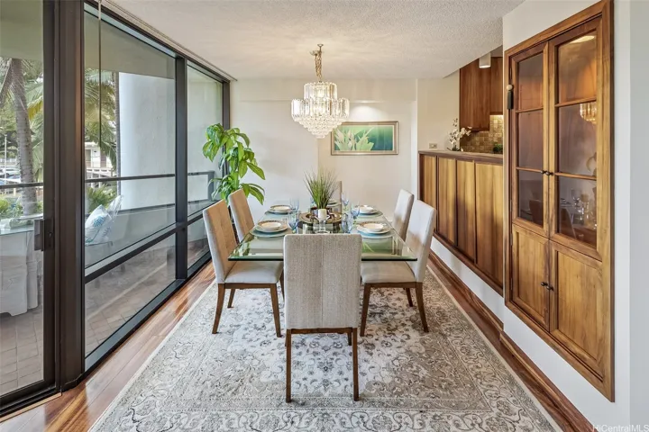 Beautiful Koa cabinetry in this lovely dining area which opens to the covered lanai and a pass through to the kitchen.