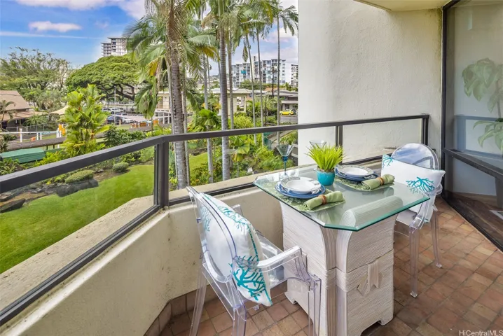 Large lawn and palm trees are so relaxing to view will dining on this covered lanai.
