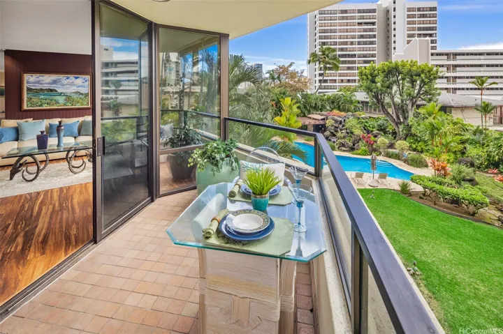 Enjoy this covered lanai from the preferred side of the building, featuring views of the pool ad garden.