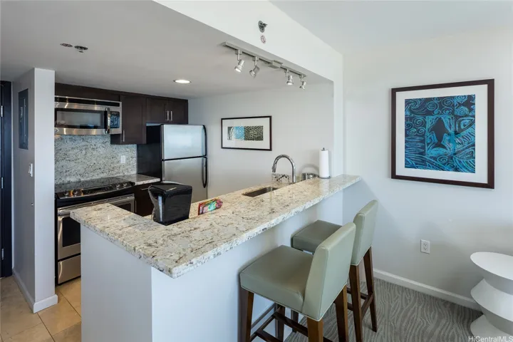 Kitchen with stainless steal appliances, granite counter tops and a spacious kitchen bar.