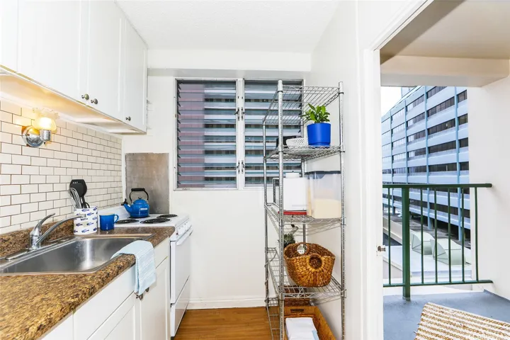 White shaker cabinets, subway tile backsplash, and additional storage rack.  Lanai just steps away to enjoy the outside.  Perfect for reading a book or a cup of joe.