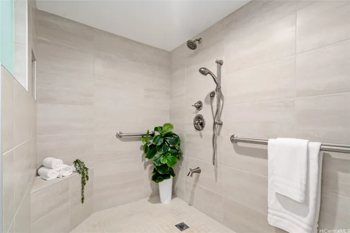 Stunning oversized tiled main shower, with bench & safety bars.