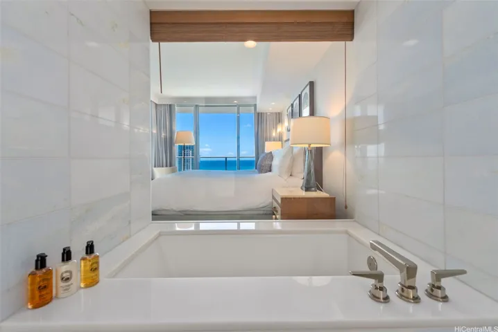 Primary bathroom with deep bathtub, ocean view
