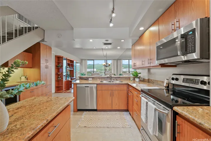 A spacious kitchen with granite counter tops and updated cabinetry and appliances.