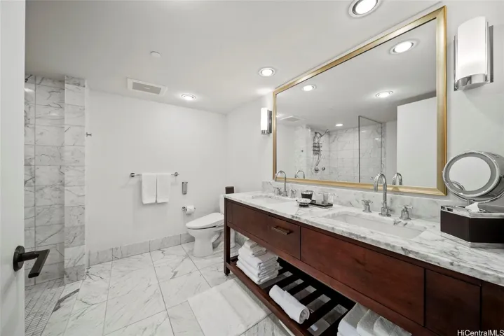 Spacious luxury bathroom with marble floors and counter tops.    Double vanities.