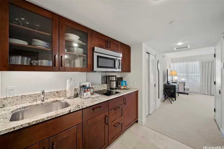 Full stocked luxury kitchenette includes stainless steel sink, granite counters, cook top, coffee maker, mini refrigerator, and microwave hood