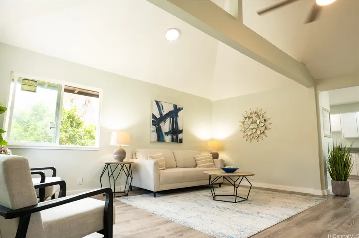 This large living room features high ceilings and a ceiling fan.