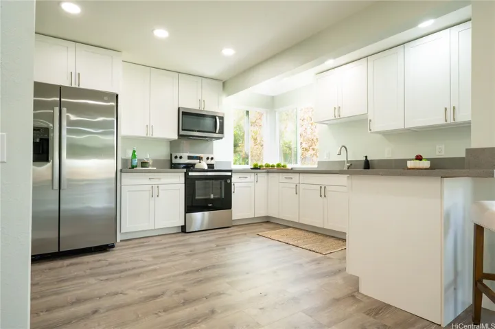 The large, open kitchen features stainless steel appliances and a breakfast bar.