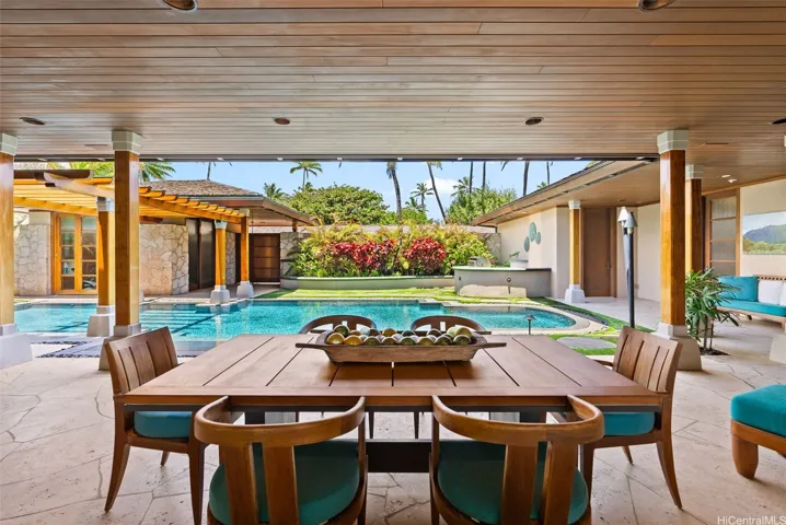 Covered dining area off the great room overlooking the pool