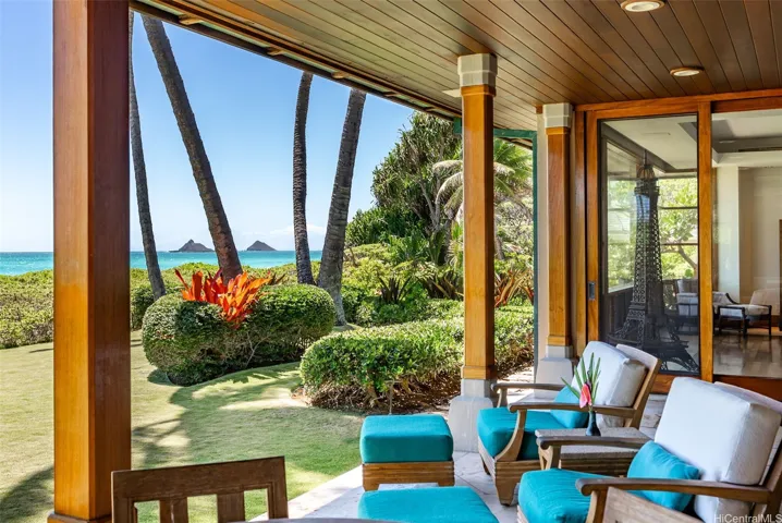 Covered oceanfront lanai overlooks the grassy yard out to the beach and ocean.