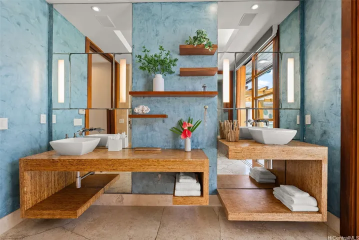 Primary bath features dual vanities with custom wood finish