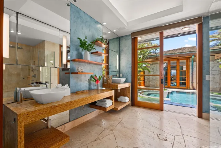 Resort-style primary bath opens onto the pool and hot tub. Large walk-in shower with multiple jets.