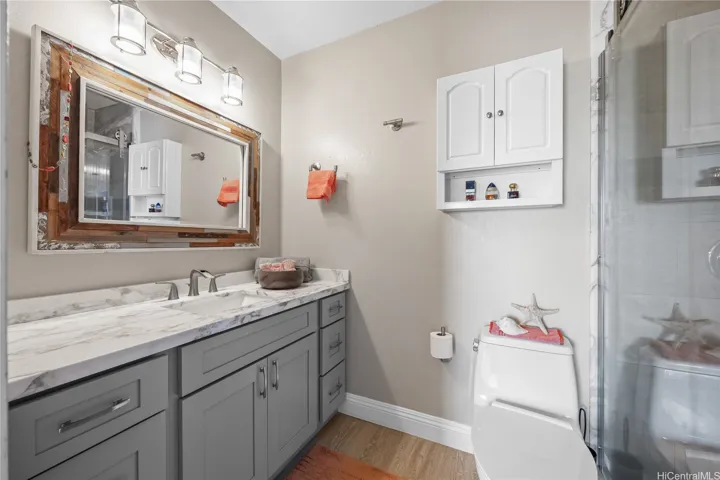 Remodeled primary bath with modern shower door and tiled surrounds