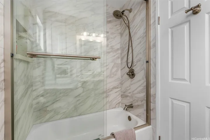 This guest bathroom has a tub/shower with glass enclosure. The primary bedroom ensuite has a walk-in shower.