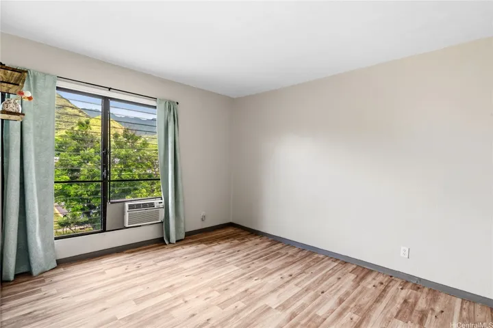 Comfortable bedroom with natural light and updated flooring.