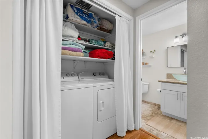 Laundry area with additional storage shelves above
