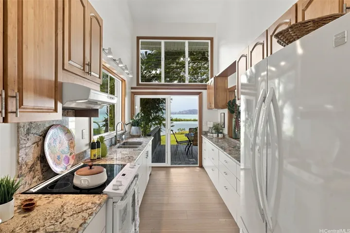 The  kitchen features high ceilings, water views, and easy access to the lanai for outdoor dining options.