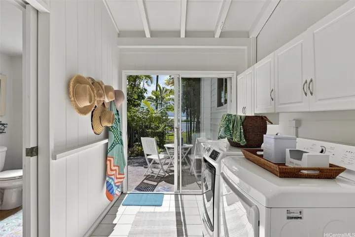 Laundry room with storage, utility sink, and access to a private gated outdoor area, perfect for pets.