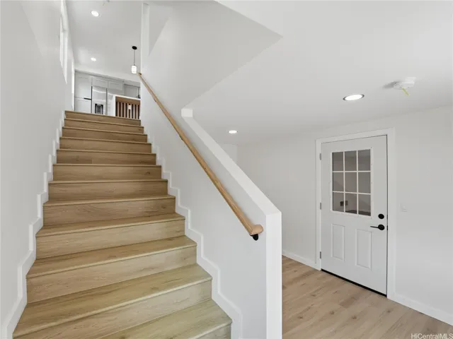 Stairs leading to the main floor with the garage entrance located to the right.