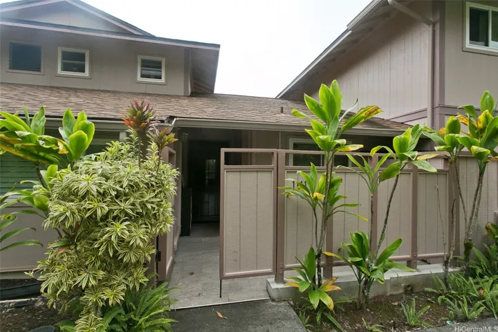 Enjoy island living with tropical landcaping and storage in front area .