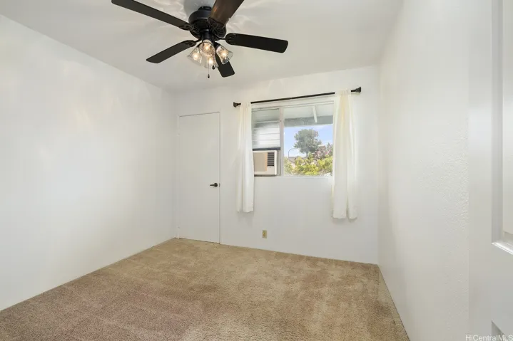 Secondary bedroom has a window AC and ceiling fan with lights plus a good sized closet.  Window covering and decorative rods stay.