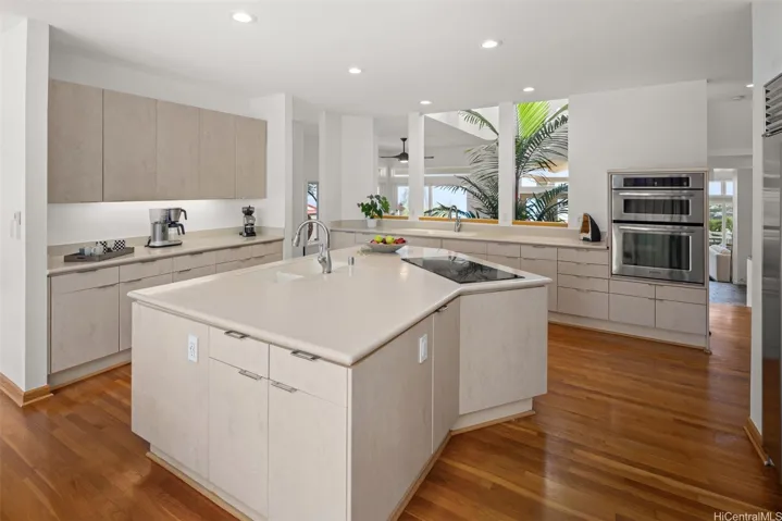 The modern kitchen features a large central island with sleek cabinets, and a walk-in pantry.